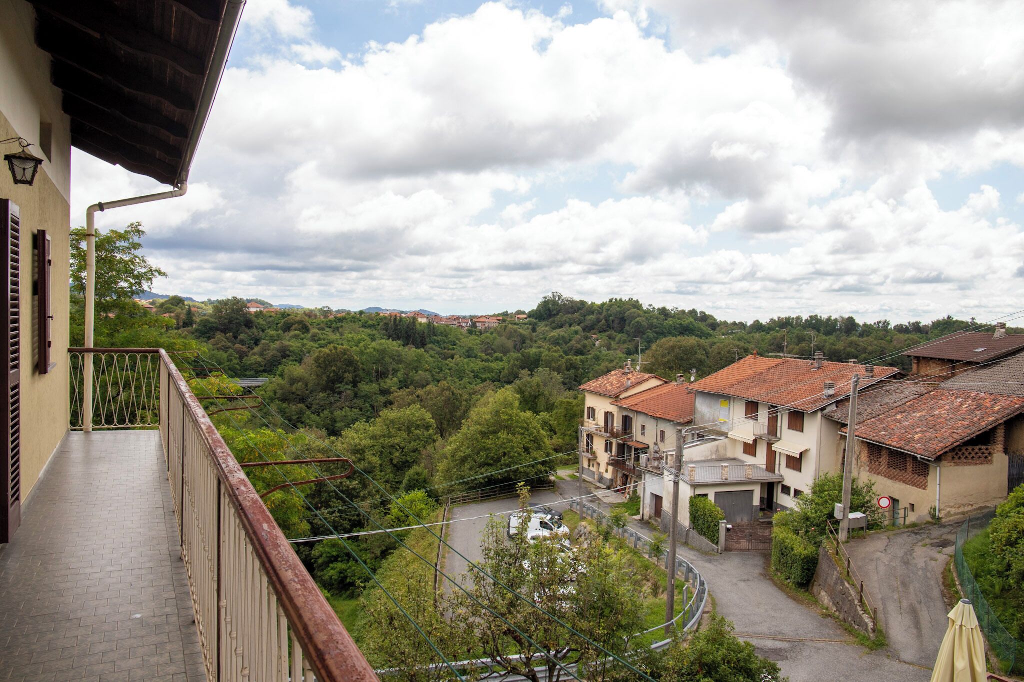 Un balcón con vistas a un pueblo, con edificios y una carretera.