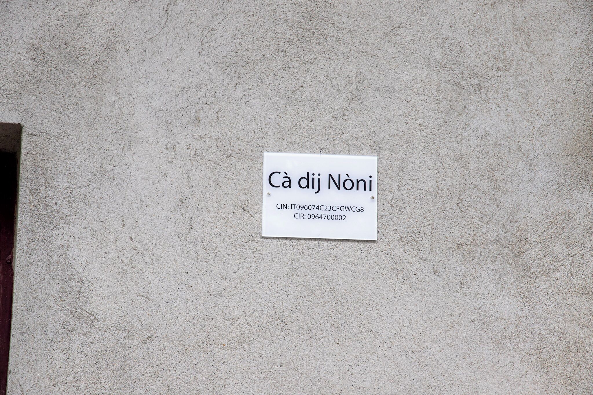 Un panneau blanc avec du texte, fixé sur un mur à texture.