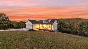A single-story house with a garage, a covered porch, and a well-maintained lawn. - Sleeps 10, HotTub, Game Room, Views, Pet Friendly (Sevierville)
