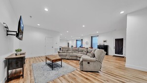 A spacious living room with a sectional sofa, a coffee table, and a flat-screen TV mounted on the wall. - Sleeps 10, HotTub, Game Room, Views, Pet Friendly (Sevierville)