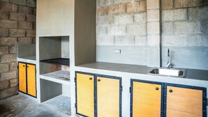 Une cuisine avec un mur en briques, un évier et des armoires en bois.