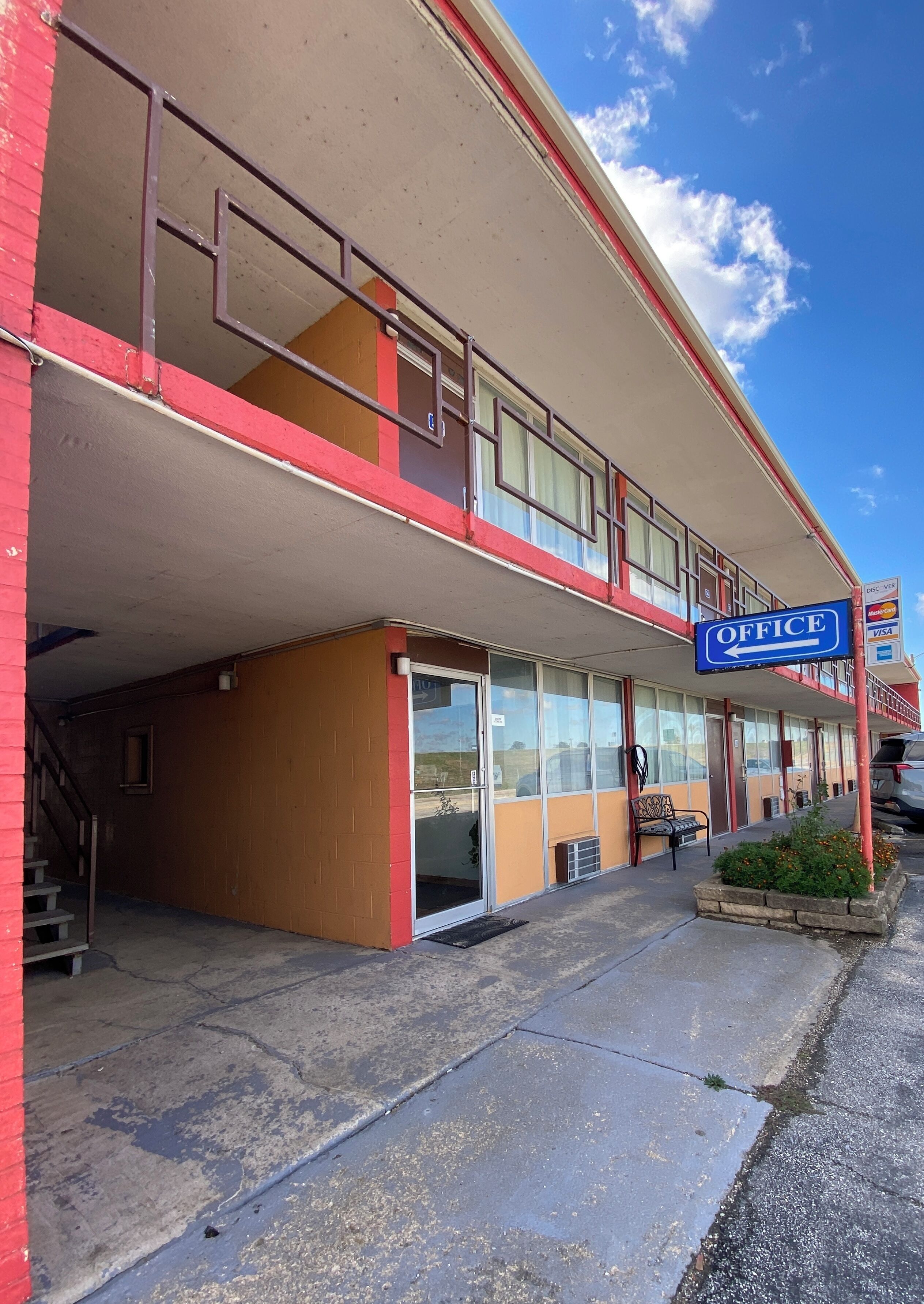 A two-story building with a sign indicating an office.