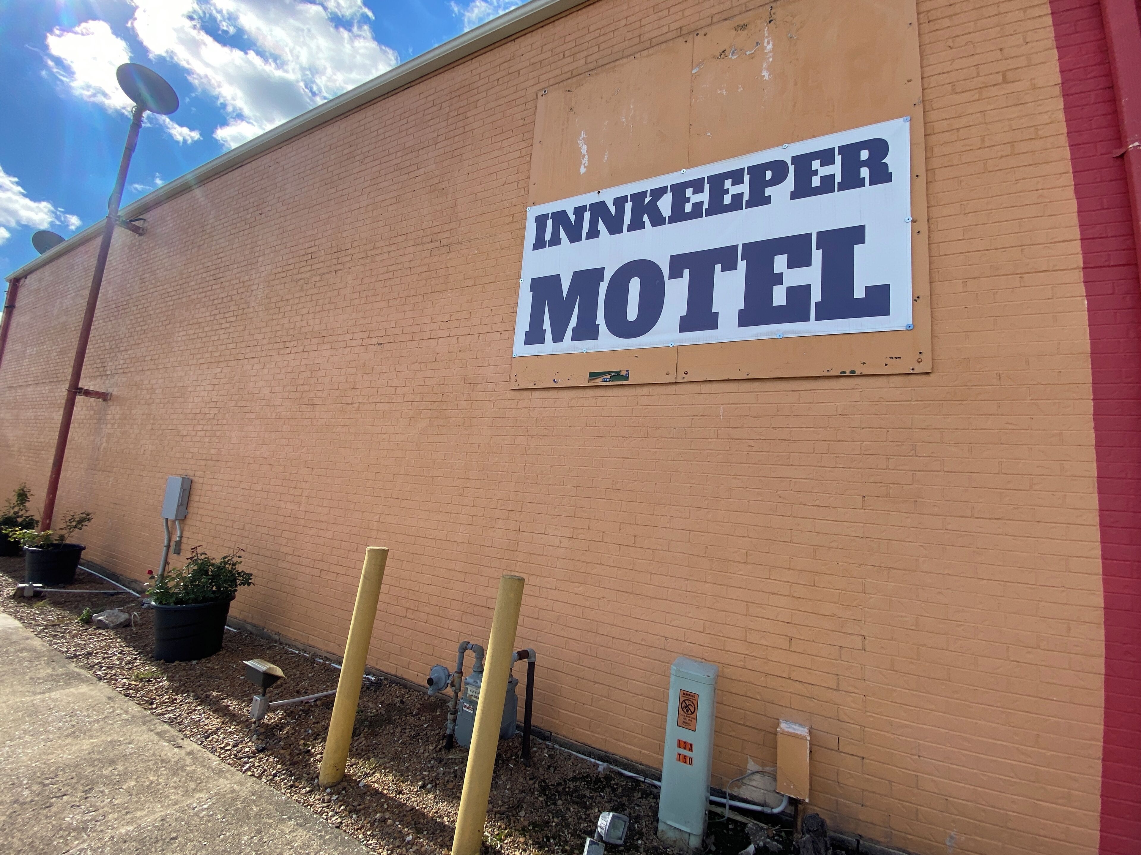 Un edificio de ladrillo con un letrero que dice 'Innkeeper Motel'.