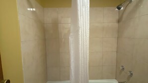 A bathroom with a bathtub, a shower, and a curtain. - Innkeeper Motel (Hamel)