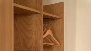 A wooden wardrobe with multiple shelves and hanging space. - Montera Apartment with Pool (Bastia)