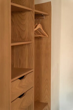 Un armario de madera con varios estantes y espacio para colgar.