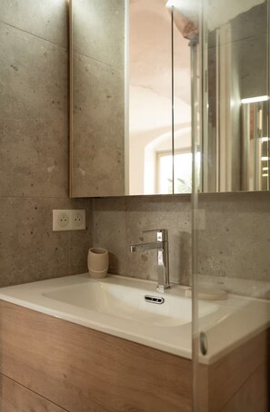 A bathroom with a white sink, a mirror, and a towel rack.
