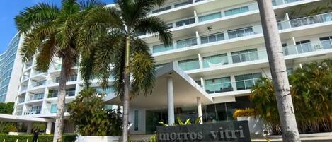 A multi-story hotel with a modern design, featuring balconies and large windows.