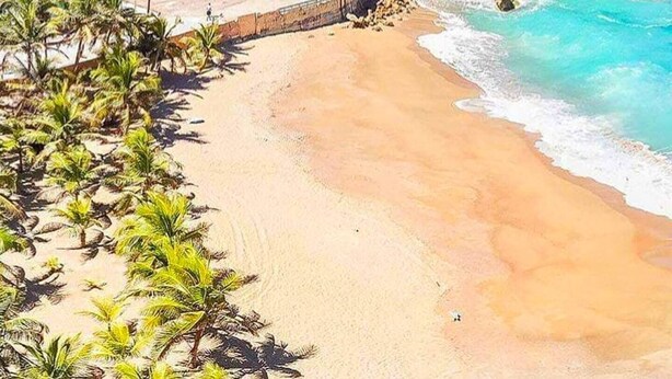 A beach with a tunnel entrance, clear blue water, and lush greenery. - Luxury stay at a budget friendly cost (San José)