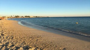 A beach with a sandy shore and calm water. - Dimora Azzurra Fronte Mare a Porto Cesareo (Porto Cesareo)