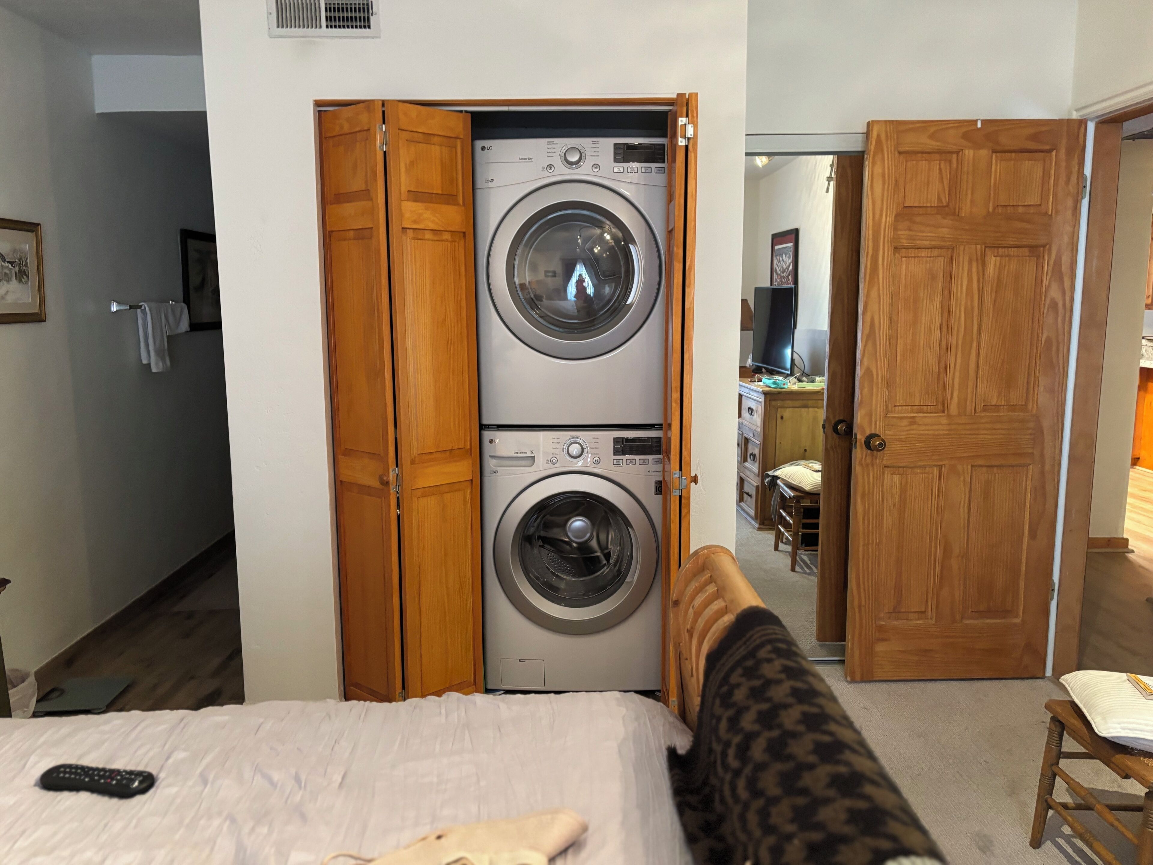 Une chambre d’hôtel avec un lit, un lave-linge et une armoire en bois.