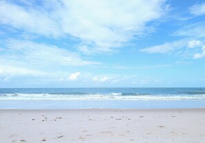 Una playa con cielo despejado y olas del océano.