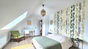 Une chambre à coucher avec un lit, un bureau, une chaise et une fenêtre.