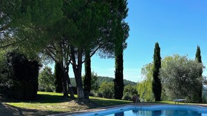 A swimming pool with metal ladders, surrounded by trees and a clear sky. - Apartment 'Villa Tiberini 4' with Panoramic View, Shared Pool and Wi-Fi (Torrita di Siena)