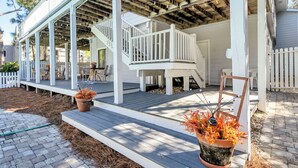 A covered porch with a wooden staircase leading to a deck, surrounded by a white picket fence. - Walk 2 Private Beach, Private Pool, Bikes, Grayton (Santa Rosa Beach)