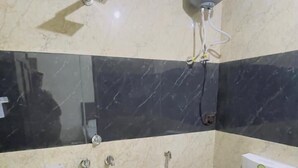 A bathroom with a toilet, a shower, and a hand dryer.