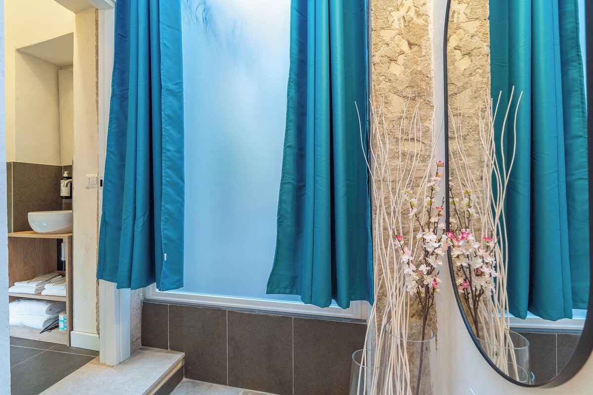 Ein Badezimmer mit Badewanne, Waschbecken und Duschbereich.