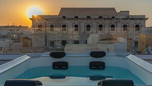Ein Whirlpool auf dem Dach mit Blick auf ein historisches Gebäude im Hintergrund.