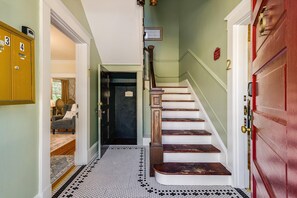 A staircase with wooden steps and a black and white tiled floor. - Ever After: Luxury, Romantic Unit + Walk Downtown (Staunton)