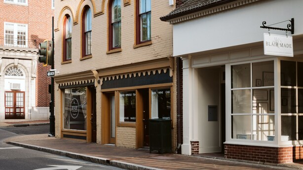 A street view of a building with a sign reading "BLAIR MADE" and storefronts with signs for "COFFEE," "EXPRESSO," "TEA," "BEER," "WINE," and "CHAI." - Ever After: Luxury, Romantic Unit + Walk Downtown (Staunton)
