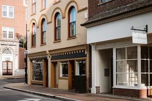 A street view of a building with a sign reading "BLAIR MADE" and storefronts with signs for "COFFEE," "EXPRESSO," "TEA," "BEER," "WINE," and "CHAI." - Ever After: Luxury, Romantic Unit + Walk Downtown (Staunton)