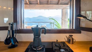 Una cocina con cafetera, estufa y vistas a las montañas a través de una ventana.