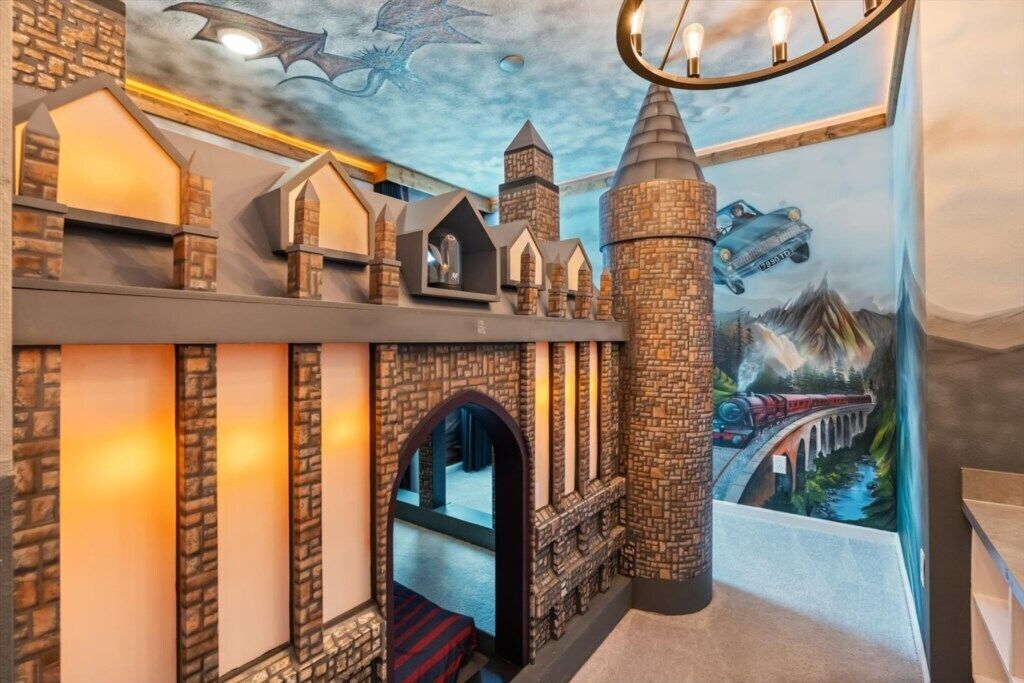 A room with a brick wall, a wooden staircase, and a mural of a dragon and a castle.