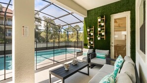 Un balcon avec une piscine, un canapé et une table basse.