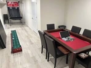 Une table de billard recouverte dâun drap de feutre rouge, des jetons de poker et une table de jeu de palet avec trois palets.