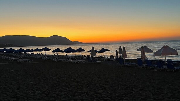 A beach with sun loungers and umbrellas, a calm sea, and mountains in the background. - Villa - Sleeps 6 - Near Local Attractions (Limassol)