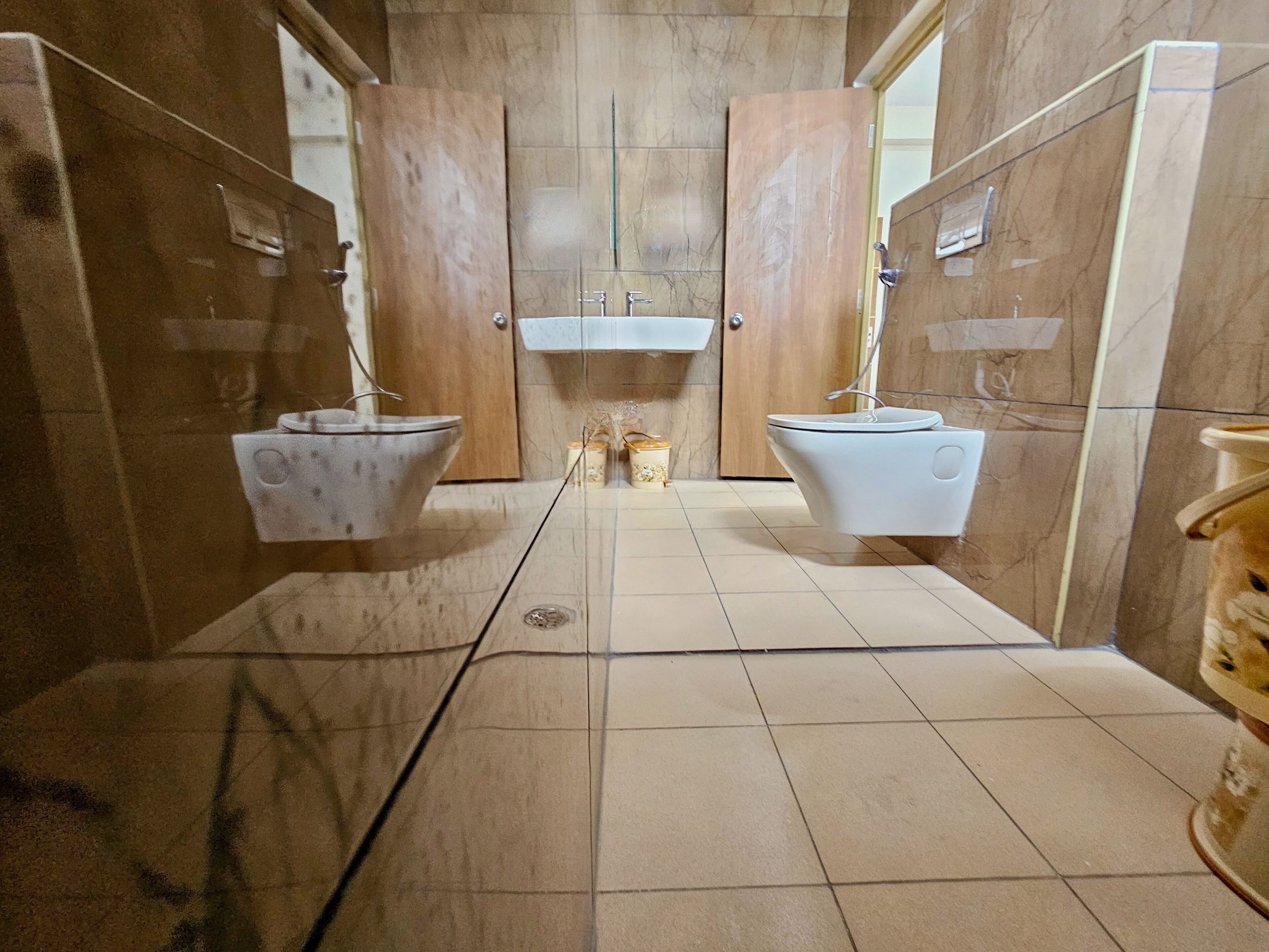 A bathroom with two sinks, a mirror, and a toilet.