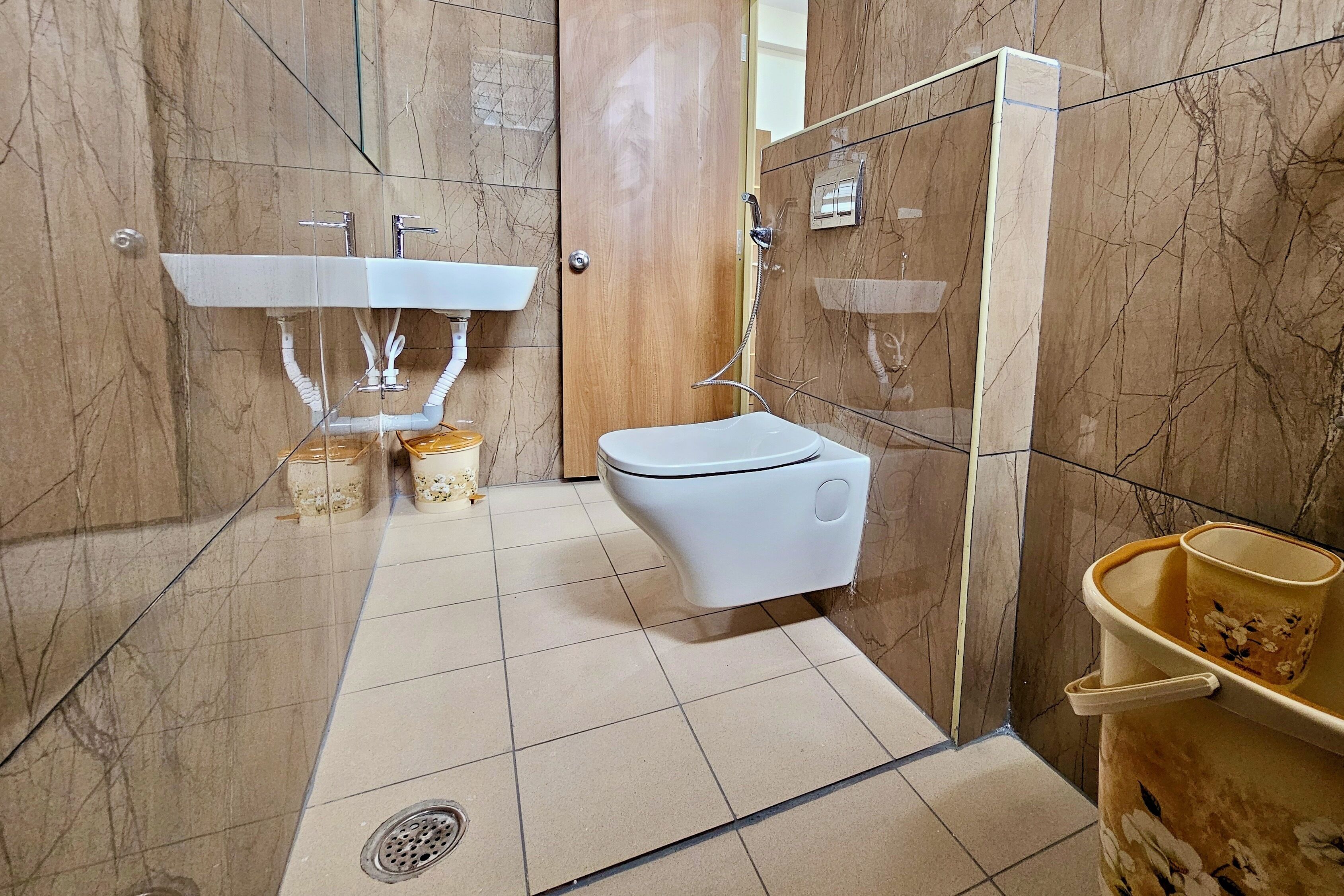 A bathroom with a white toilet, a sink, and a shower area.
