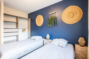 Une chambre avec deux lits, une armoire et des éléments de décoration murale.