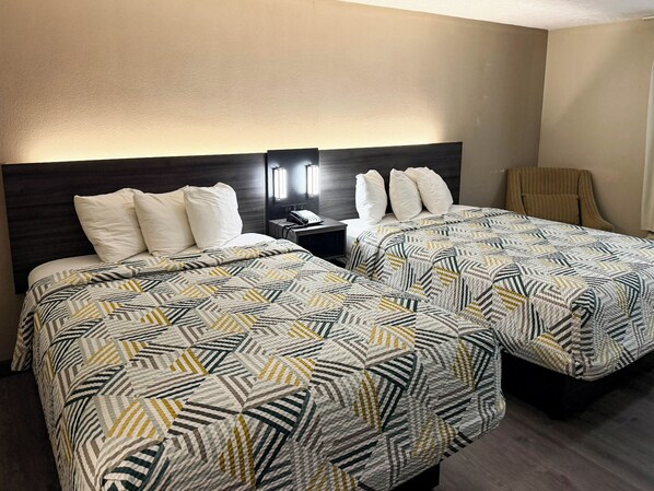A hotel room with two beds, a nightstand with a phone, and a chair. - Studio 6 - Stafford, Va - Quantico (Stafford)