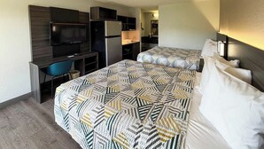 A hotel room with two beds, a desk, a TV, and a kitchenette. - Studio 6 - Stafford, Va - Quantico (Stafford)