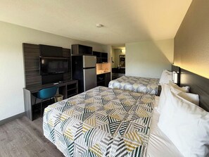 A hotel room with two beds, a desk, a TV, and a kitchenette. - Studio 6 - Stafford, Va - Quantico (Stafford)