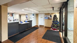A reception area with a Christmas tree, a reception desk, and a door. - Studio 6 - Stafford, Va - Quantico (Stafford)