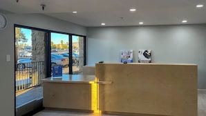 A reception desk with a view of parked cars outside. - MOTEL 6 Victorville Green Tree Blvd (Victorville)