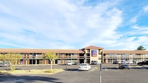 A multi-story hotel with a parking lot in front. - MOTEL 6 Victorville Green Tree Blvd (Victorville)