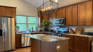 Una cocina moderna con armarios de madera, electrodomésticos de acero inoxidable y una isla grande.
