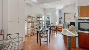 Una cocina moderna con armarios de madera, horno empotrado y comedor con mesa y sillas de vidrio.