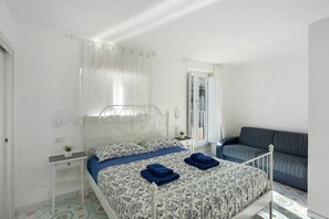 Una camera da letto con un letto, un comodino e un divano.