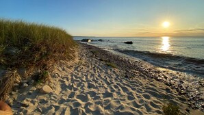 A sandy beach with pebbles and grass, leading to the water. - Amazing sunsets, a welcoming home, and island adventures.  Lifetime memories! (Chilmark)