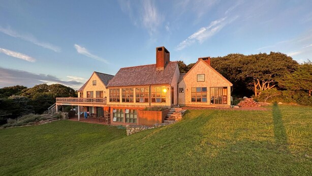 A large, two-story house with a spacious front yard and a covered patio area. - Amazing sunsets, a welcoming home, and island adventures.  Lifetime memories! (Chilmark)