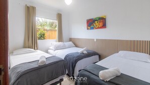 A hotel room with three beds, a ceiling fan, a window with curtains, and a painting on the wall. - Apt w/ Barbecue 500m From the Beach Pbr1003 (Porto Seguro)