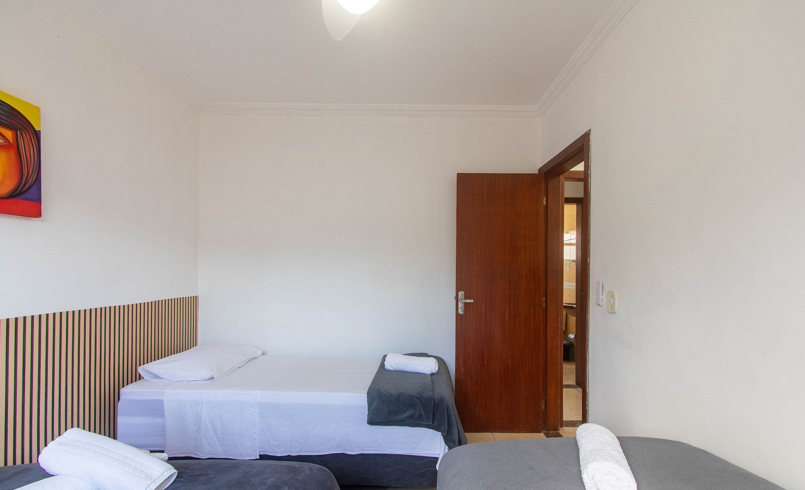 A hotel room with two beds, a wooden headboard, and a painting on the wall.