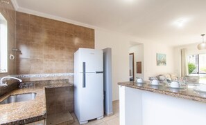 A modern kitchen with a built-in refrigerator, granite countertops, and a large island with seating. - Apt w/ Barbecue 500m From the Beach Pbr1003 (Porto Seguro)