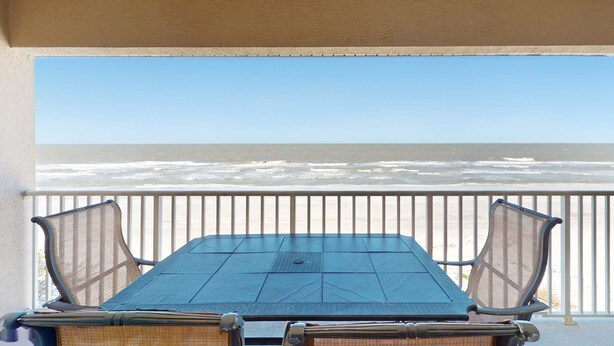 A covered outdoor seating area with a view of the ocean. - Welcoming Gulf front condo with pool and hot tub direct beach access (Indian Rocks Beach)