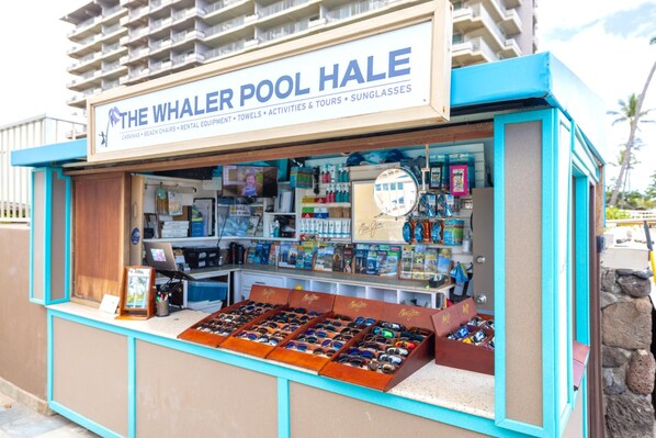 A kiosk named "The Whaler Pool Hale" offering sunglasses, beach chairs, and rental equipment.