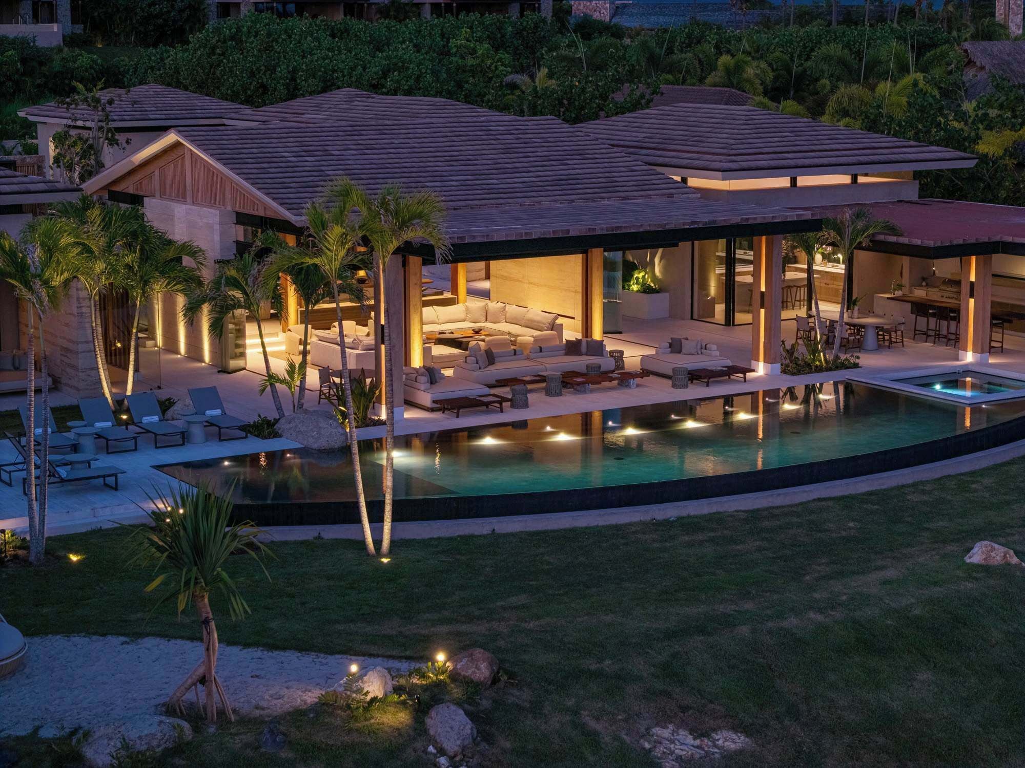 Ein modernes Resort mit Pool, Sitzgelegenheiten im Freien und einer überdachten Lounge-Bereich.